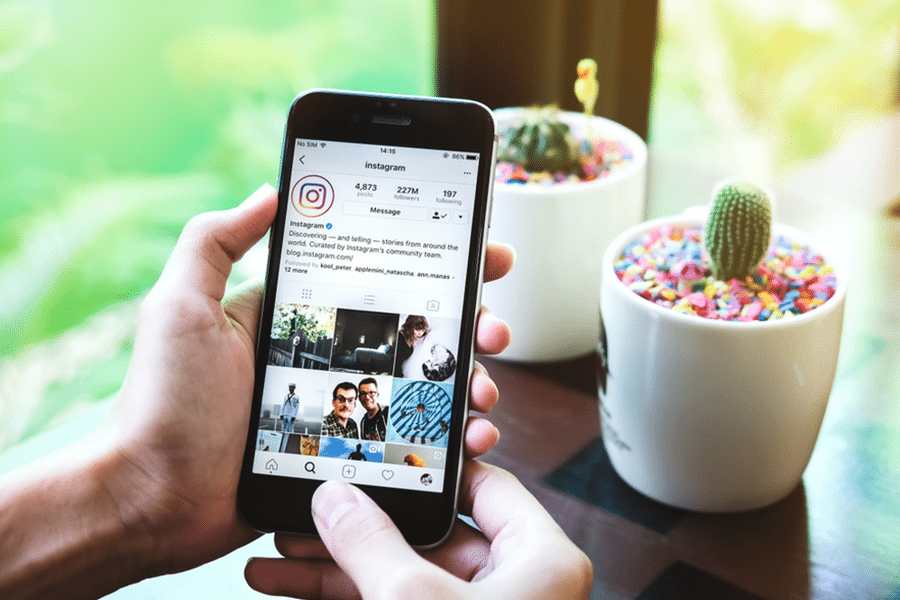 A woman holds Apple iPhone 6S with Instagram application on the screen.